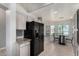 Modern kitchen with stainless steel appliances, white cabinets, and tile flooring, bathed in natural light at 13373 W Boca Raton Rd, Surprise, AZ 85379