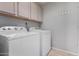 Laundry room includes a washing machine and dryer with cabinets above the units at 13373 W Boca Raton Rd, Surprise, AZ 85379