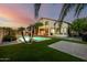 A spectacular backyard with a dazzling pool, covered patio, and lush artificial turf at 13636 W Calavar Rd, Surprise, AZ 85379