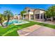 Spacious backyard with a pool, covered patio, cabana, and green lawn at 13636 W Calavar Rd, Surprise, AZ 85379