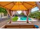 Comfortable backyard seating area with a view of the pool and outdoor dining space for easy entertaining at 13636 W Calavar Rd, Surprise, AZ 85379