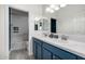Beautifully updated bathroom with double vanity with blue cabinets, and shower over tub with custom tile at 13636 W Calavar Rd, Surprise, AZ 85379