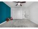 Bedroom with carpet, ceiling fan, closet, and brightly painted accent wall at 13636 W Calavar Rd, Surprise, AZ 85379