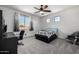 Well-lit bedroom with carpet, ceiling fan, desk, and decorative chair at 13636 W Calavar Rd, Surprise, AZ 85379
