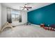 Bedroom with carpet, large window, ceiling fan, and painted accent wall at 13636 W Calavar Rd, Surprise, AZ 85379