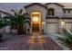 Inviting home featuring a grand archway entrance, desert landscaping, and path lighting at 13636 W Calavar Rd, Surprise, AZ 85379