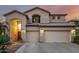 Charming two-story home with a three-car garage and desert landscaping is bathed in a warm sunset glow at 13636 W Calavar Rd, Surprise, AZ 85379