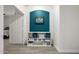 Stylish hallway with built-in shelving, decorative teal accent wall and modern gray-wood look tile flooring at 13636 W Calavar Rd, Surprise, AZ 85379