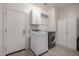 Well-lit laundry room with modern appliances and storage cabinets at 13636 W Calavar Rd, Surprise, AZ 85379