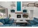 Comfortable living room with plush blue sofas, a fireplace, and decorative shelving at 13636 W Calavar Rd, Surprise, AZ 85379