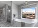 Bright bathroom featuring a free-standing tub, a glass shower, and a decorative chandelier at 14609 S 24Th Way, Phoenix, AZ 85048