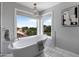 Bright bathroom featuring a free-standing tub, marble tile floor, and a decorative chandelier at 14609 S 24Th Way, Phoenix, AZ 85048