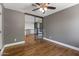 Bedroom featuring wood floors, neutral walls, a ceiling fan, and an iron-framed door at 14609 S 24Th Way, Phoenix, AZ 85048