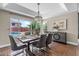 Dining area boasts an elegant chandelier, large windows with a pool view, and stylish furnishings at 14609 S 24Th Way, Phoenix, AZ 85048