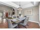 Open dining area with modern chandelier and views to the stairs with wooden railings, and brick entrance at 14609 S 24Th Way, Phoenix, AZ 85048