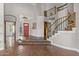 Bright and open foyer with beautiful tile flooring, staircase with wooden rails, and an arched doorway at 14609 S 24Th Way, Phoenix, AZ 85048