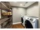 Laundry room with modern washer/dryer units, shelving, neutral walls, and Saltillo tile flooring at 14609 S 24Th Way, Phoenix, AZ 85048