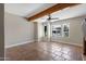 Spacious living room featuring Saltillo tile flooring, a beam ceiling, and bright windows with neighborhood views at 14609 S 24Th Way, Phoenix, AZ 85048