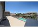 Balcony overlooking backyard pool and patio area with tropical landscaping at 14770 W Columbine Dr, Surprise, AZ 85379