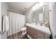 Bright bathroom featuring a wood vanity, framed mirror, and a shower with a decorative curtain at 14770 W Columbine Dr, Surprise, AZ 85379