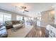 Cozy living room open to dining and kitchen areas featuring wood flooring and natural light at 14770 W Columbine Dr, Surprise, AZ 85379
