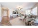 Spacious living room featuring hardwood floors, a ceiling fan, a large TV, and lots of comfortable seating at 14770 W Columbine Dr, Surprise, AZ 85379