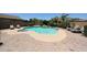 Backyard swimming pool surrounded by a brick patio and lush landscaping at 14770 W Columbine Dr, Surprise, AZ 85379