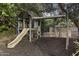 Backyard playground area with a slide, swing set, and mulch ground cover under mature trees at 1522 W Myrtle Ave, Phoenix, AZ 85021