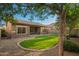 Backyard featuring green grass, lush trees, patio, and privacy walls at 15674 W Mackenzie Dr, Goodyear, AZ 85395