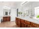 A large bathroom offers double sinks, wood cabinets, a large mirror, and recessed lighting at 15674 W Mackenzie Dr, Goodyear, AZ 85395