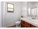 A bathroom featuring a white vanity, toilet, and window at 15674 W Mackenzie Dr, Goodyear, AZ 85395