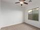 An empty bedroom with carpet, ceiling fan, and white walls at 15674 W Mackenzie Dr, Goodyear, AZ 85395