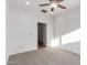Bright, carpeted bedroom featuring a ceiling fan and doorway leading to an adjoining room at 15674 W Mackenzie Dr, Goodyear, AZ 85395