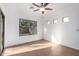 Bright bedroom with tile flooring, a ceiling fan, and sliding glass doors to the backyard at 15674 W Mackenzie Dr, Goodyear, AZ 85395