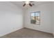 An empty bedroom with carpet, ceiling fan, and white walls at 15674 W Mackenzie Dr, Goodyear, AZ 85395