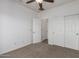 An empty bedroom with carpet, ceiling fan, and white walls at 15674 W Mackenzie Dr, Goodyear, AZ 85395