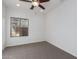 Neutral bedroom with a window, carpet, and ceiling fan at 15674 W Mackenzie Dr, Goodyear, AZ 85395