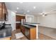 Well-lit kitchen with modern appliances, dark wood cabinets, and a breakfast bar at 15674 W Mackenzie Dr, Goodyear, AZ 85395