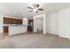 Inviting living area with ceiling fan, seamlessly connected to the kitchen, with tile and carpet flooring at 15674 W Mackenzie Dr, Goodyear, AZ 85395