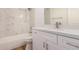 Bright bathroom featuring a tub with marble tile and a white vanity with a quartz countertop at 162 N Hunt W Dr, Mesa, AZ 85203
