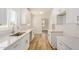 Modern kitchen with white cabinets, quartz countertops, stainless steel sink, and wood-look flooring at 162 N Hunt W Dr, Mesa, AZ 85203