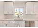Bright kitchen featuring white quartz countertops, stainless steel sink, and a view of the backyard at 162 N Hunt W Dr, Mesa, AZ 85203