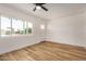 Bright living room with modern ceiling fan, wood-look floors, and natural light from large window at 162 N Hunt W Dr, Mesa, AZ 85203