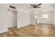 Open living room featuring modern light fixture, wood-look floors, and freshly painted white walls at 162 N Hunt W Dr, Mesa, AZ 85203
