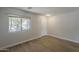 Bright, empty room featuring wood floors, a window overlooking mature tree and a white door at 1671 E Silktassel Trl, San Tan Valley, AZ 85143