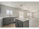 Kitchen with gray cabinets, an island with white countertop, and stainless appliances at 1671 E Silktassel Trl, San Tan Valley, AZ 85143