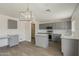 Bright kitchen with gray cabinets, an island, stainless appliances, and open pantry at 1671 E Silktassel Trl, San Tan Valley, AZ 85143