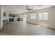 Spacious living room with modern ceiling fan opening to the kitchen with grey cabinets at 1671 E Silktassel Trl, San Tan Valley, AZ 85143