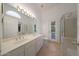 Bright bathroom featuring double sinks, large mirror, and separate glass-enclosed shower at 19007 N 79Th Dr, Glendale, AZ 85308