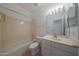 Well-lit bathroom featuring a tub, toilet, and vanity with neutral-toned tile flooring at 19007 N 79Th Dr, Glendale, AZ 85308
